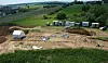 Une vue du site en cours de fouilles. La structure blanche, à gauche, protégeait l'accès au puits.