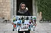 Ashwaq Haji, une femme Yazidi, utilisée par Daesh comme esclave sexuelle, tient des portraits de victimes de jihadistes de son village dans le nord de l'Irak, le 15 août 2018.