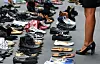 Des personnes regardent des rangées de chaussures placées devant JPMorgan Chase sur Park Avenue à New York le 2 août 2017 lors d'une manifestation pour s'opposer à la politique d'immigration de Donald Trump.