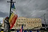 Une personne hisse le drapeau LGBTQI+ devant le Parlement grec à Athènes.
