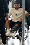 Sinani en fauteuil roulant au Findel. Un signe moyen.