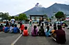 Des enfants sont rassemblés sur la place principale alors que le volcan Fuego entre en éruption à Alotenango, à environ 65 km au sud-ouest de Guatemala City, mardi.