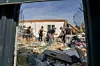Des personnes déblaient les décombres d'une maison endommagée après le passage d'une tornade à Pomas.