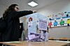 Une électrice déposant son bulletin dans une urne lors des élections législatives anticipées en Serbie, dans un bureau de vote à Belgrade, ce dimanche.