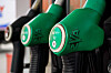 Des pistolets verts de pompe à carburant alignés dans une station-service