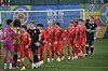 Des jeunes footballeurs en rouge entrent sur le terrain avant un match international.