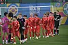 Des jeunes footballeurs en rouge entrent sur le terrain avant un match international.