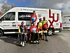 Des jeunes cyclistes médaillés posent avec leurs vélos devant des fourgons de la fédération luxembourgeoise.